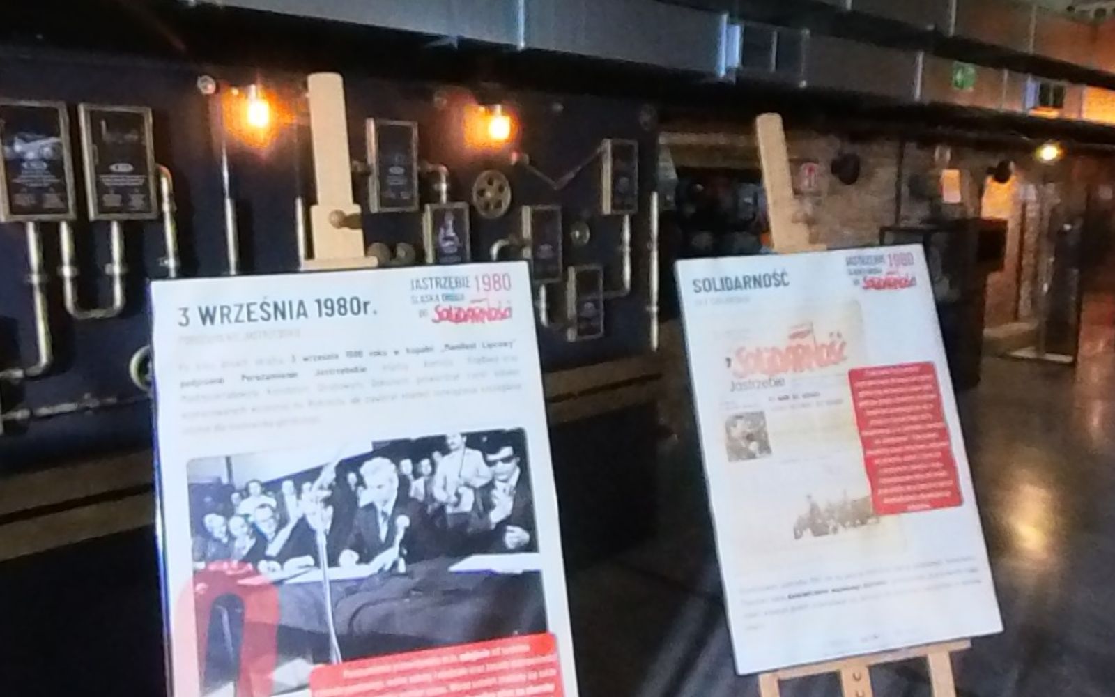 Dwie plansze na sztalugach: „3 września 1980 r.” z czarno-białą fotografią oraz „Solidarność” z reprodukcją gazety.